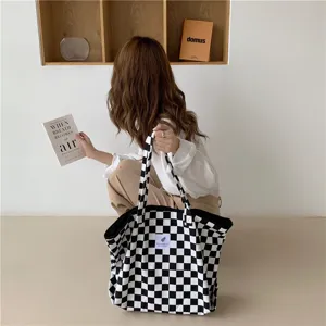 Detail du sac cabas en toile motif damier noir et blanc grande capacite dans une scene quotidienne.