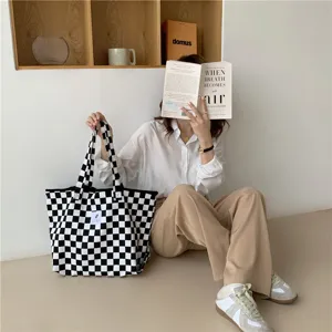 Vue rapprochée détaillée du sac en toile à damier noir et blanc présenté en scène.
