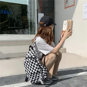 Vue détaillée d'un sac à dos en toile à carreaux noir et blanc chic pour le style urbain.