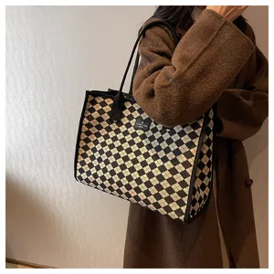 Vue détaillée du sac cabas à carreaux stylé porté avec un manteau marron, spacieux.