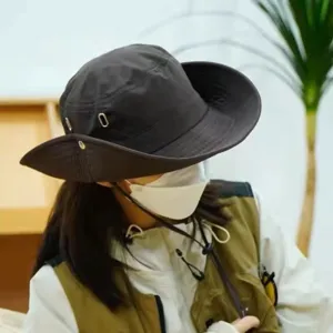 Dark grey outdoor hiking bucket hat with wide brim, metal eyelets and wind strap.