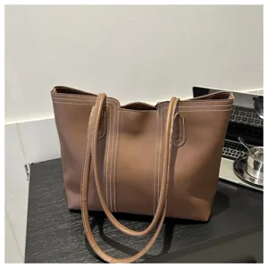 Brown PU leather tote bag detail, featuring contrast white stitching and double shoulder straps.