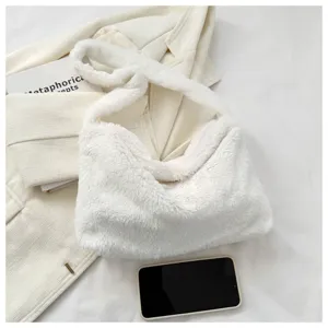 Detailed view of white plush shoulder bag, soft fluffy underarm handbag texture and props.