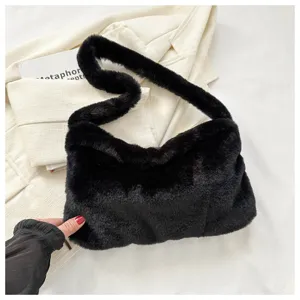 Close-up detail of the black plush shoulder bag texture, showing soft furry material and strap.