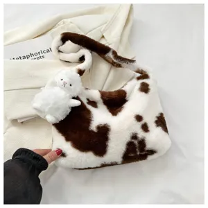 Cute plush shoulder bag with cow print pattern and fluffy rabbit pendant for daily style.
