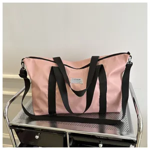 Large capacity pink travel duffel bag for women, casual shoulder tote with black straps.