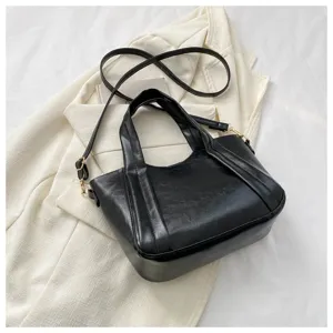 Black PU leather tote bag with top handles and adjustable shoulder strap for women daily use.