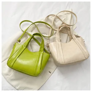 Close-up view of casual soft leather bucket bags in green and beige, stylish crossbody style.