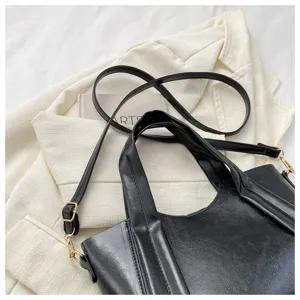 Black faux leather tote bag detail, stylish soft PU shoulder handbag with hardware.