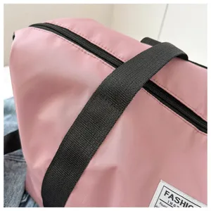 Pink travel duffel bag with black straps, large capacity casual shoulder bag for women.