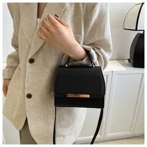 Detailaufnahme der schwarzen strukturierten Mini-Umhängetasche mit elegantem Metallverschluss.