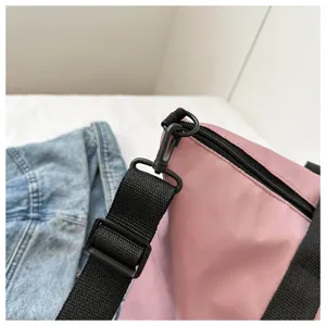 Detail view of pink shoulder bag strap, durable black nylon webbing and smooth zipper.