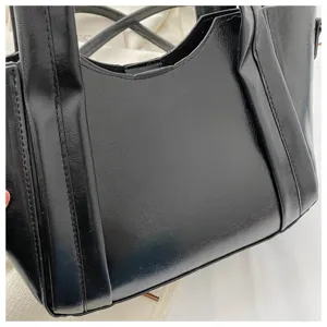 Black faux leather handbag detail close-up, stylish soft texture shoulder crossbody tote bag.