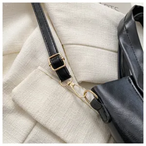 Black PU leather bucket bag detail strap and gold hardware close-up stylish daily accessory.