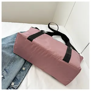 Large capacity pink shoulder travel bag detail showing durable fabric and black sturdy straps.