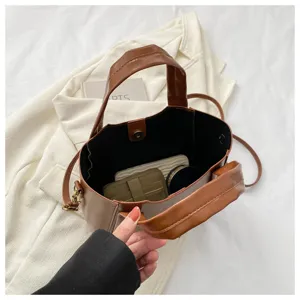 Brown PU leather bucket bag detail view, showing interior space and handle structure.