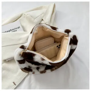 Close-up detail of fluffy cow print underarm shoulder bag interior lining storage display.