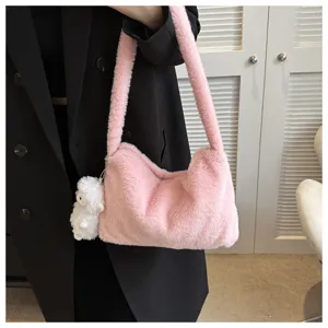 Close up view of the pink fluffy shoulder bag with cute white plush pendant accessory detail.