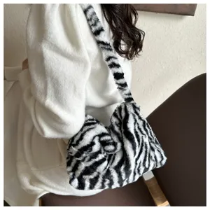 Chic black and white zebra print plush shoulder bag, trendy fuzzy underarm bag for women.