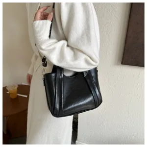 Detail shot of a stylish black leather bucket handbag, elegant shoulder bag for women.
