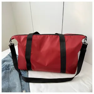 Detailed view of the large capacity red travel tote bag showing durable fabric and sturdy straps.
