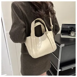 Casual soft leather women handbag detail view, minimalist beige tote and crossbody bag style.