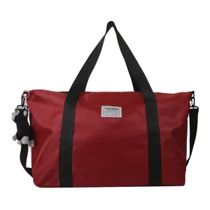Large capacity red nylon travel tote bag with black straps and cute monkey keychain.