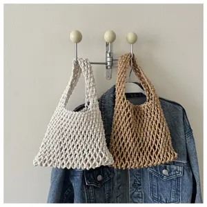 Handcrafted macrame fishnet bag detail shot, boho style woven handbag hanging on wall.