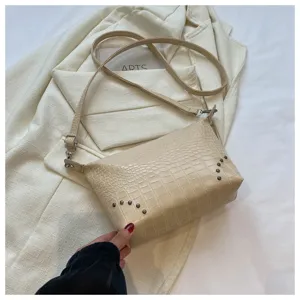 Beige τσάντα χιαστί με μοτίβο κροκόδειλου και μεταλλικά πριτσίνια, κομψό αξεσουάρ.