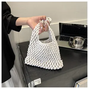 Handmade white macrame net bag detail, showing close-up woven cotton rope texture and handle.