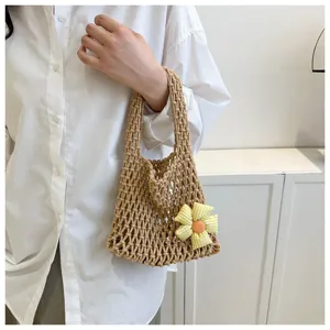 Closeup of a casual woven mesh handbag featuring a cute yellow plaid fabric flower pendant.