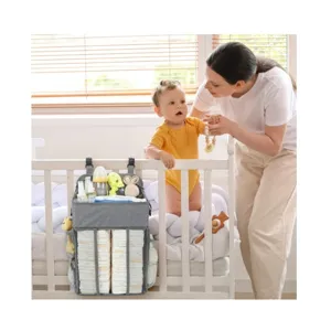 Hanging baby diaper organizer caddy for crib nursery storage with multiple pockets.