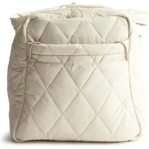 Close up view of the beige quilted duffel bag showing diamond pattern texture and front pocket.