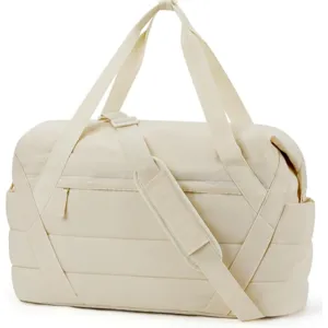 Dettaglio della borsa da palestra trapuntata color crema con tracolla regolabile e zip.