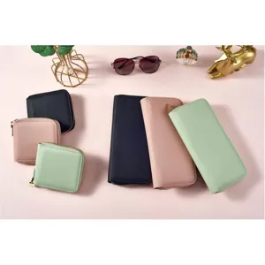 Detailed shot of stylish zipper wallets in assorted colors neatly arranged on pink backdrop.