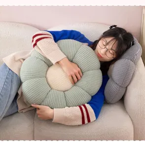 Detail view of the soft flower-shaped plush cushion, showcasing cozy home decor use and texture.