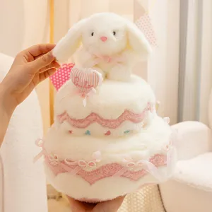 Adorable peluche gâteau à deux étages avec lapin blanc et nœuds roses pour cadeau d'anniversaire.