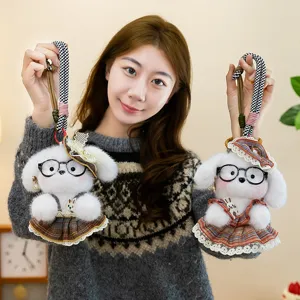 Close-up detail shot of cute puppy plush keychains with stylish glasses and plaid dresses.
