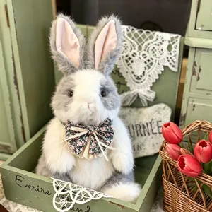 Detailopname van schattig realistisch pluche konijn in houten kist met strik.