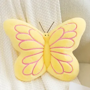 Close-up detail of the yellow butterfly plush pillow, soft furry texture with pink stitching.