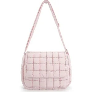 Close up view of the pink quilted crossbody bag showing soft puffer texture and strap detail.