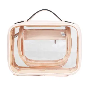 Large capacity transparent travel cosmetic bag with leather trim, handle and multiple compartments.