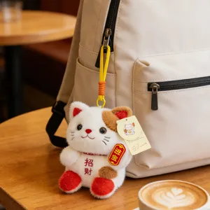 Cute lucky cat plush pendant detail shot, fluffy material and embroidery design for bags.