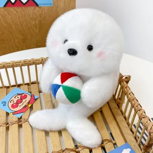 Detailed view of cute white seal plush toy holding a colorful beach ball in a wooden basket.