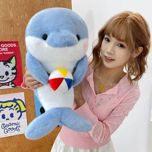 Detailed view of a cute plush dolphin toy holding a small colorful ball, soft and cuddly gift.