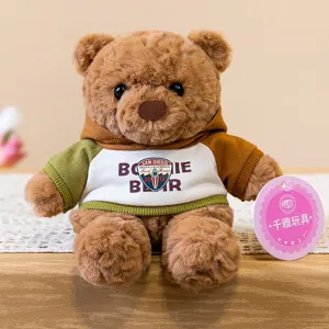 Simpatico orsacchiotto di peluche marrone con felpa con cappuccio, morbida bambola da scrivania.