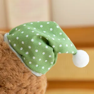 Detailed close-up shot showing the cute green polka dot sleep hat texture of the plush bear.