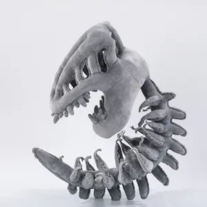 Vista detallada del juguete de peluche con esqueleto de dinosaurio gris y textura suave.