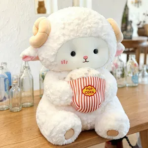 Close-up of cute sitting sheep plush toy holding popcorn bucket, soft fabric detail.