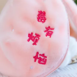 Pink plush toy detail close up showing cute embroidered text and soft fabric texture for bag.